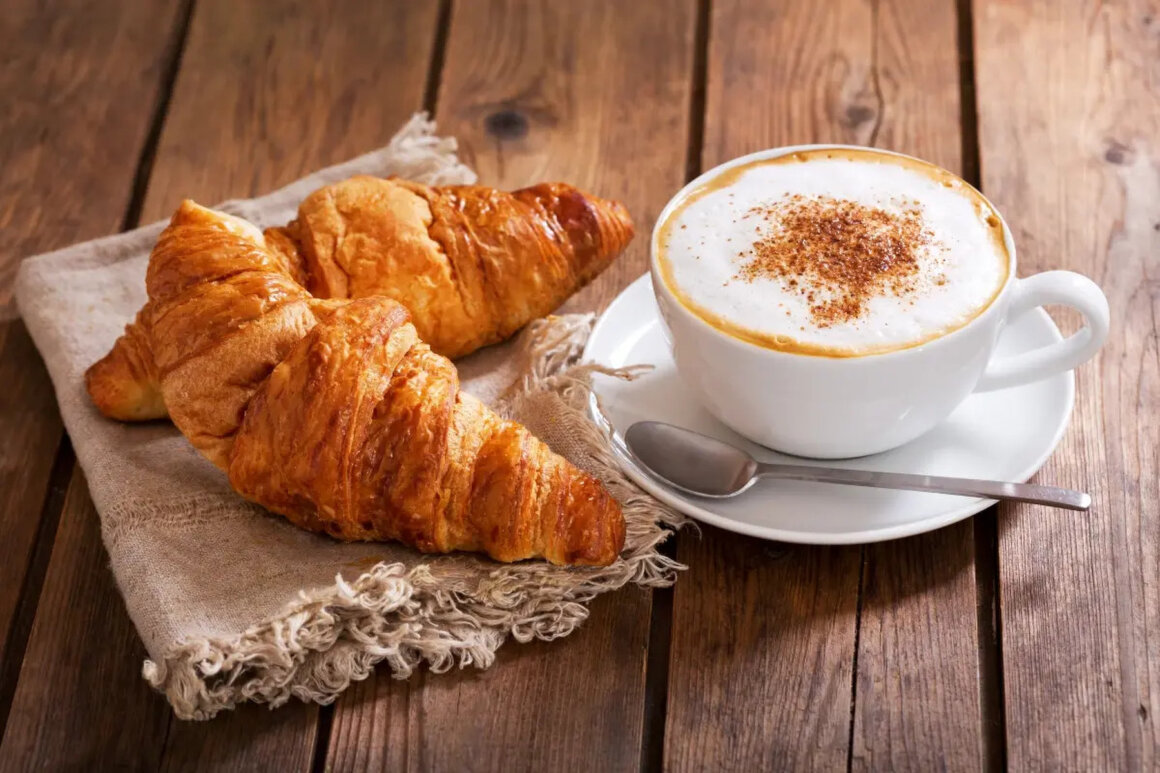 Tavola apparecchiata per la colazione con caffè, pane e marmellata